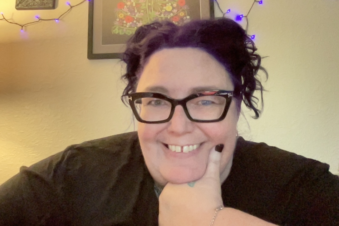 fat white woman's face. leaning on her chin. black glasses. purple hair up in pigtails.